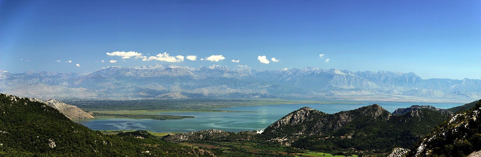 Skadarské jezero u Shkodry — panorama největšího jezera Balkánu s horami na obzoru