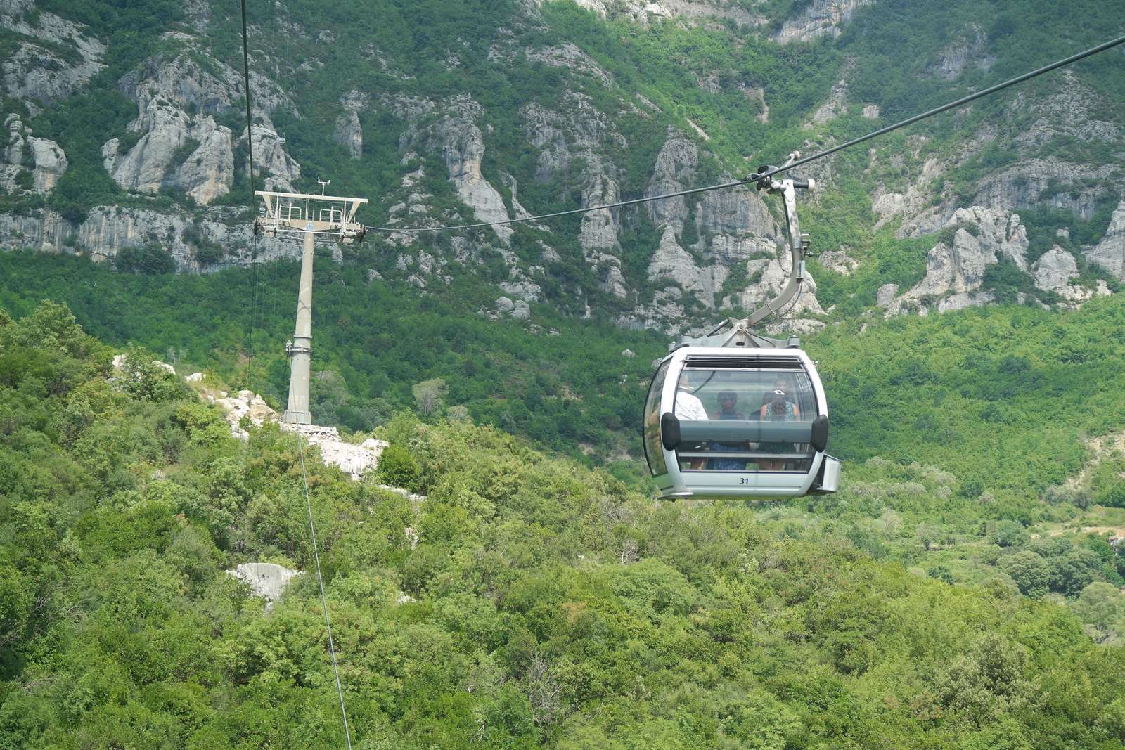 Kabinka lanovky Dajti Ekspres stoupá k vápencovým skalám hory Dajti nad Tiranou