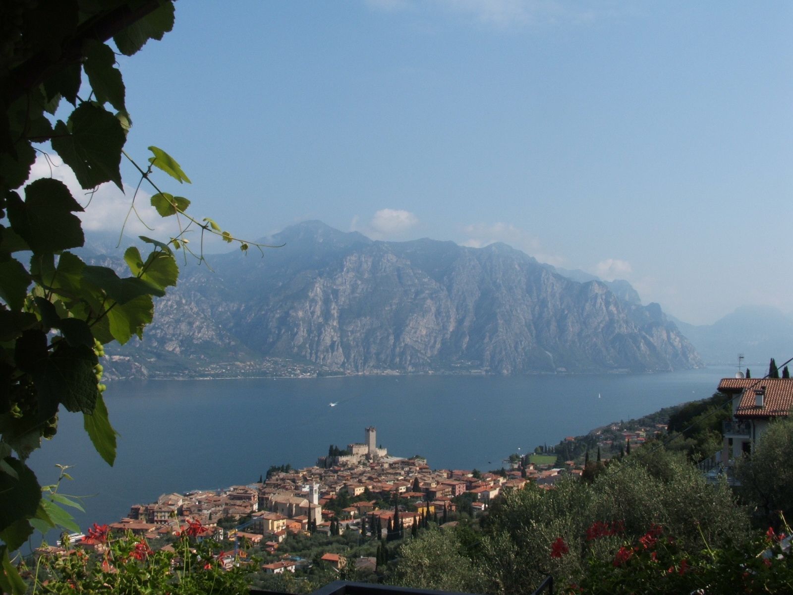 Městečko Malcesine se Scaligerským hradem na břehu Lago di Garda, v pozadí strmé skalní stěny nad jezerem