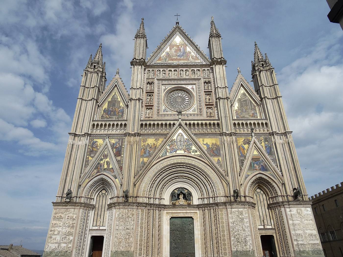 Zlatá mozaiková fasáda katedrály Duomo v Orvietu