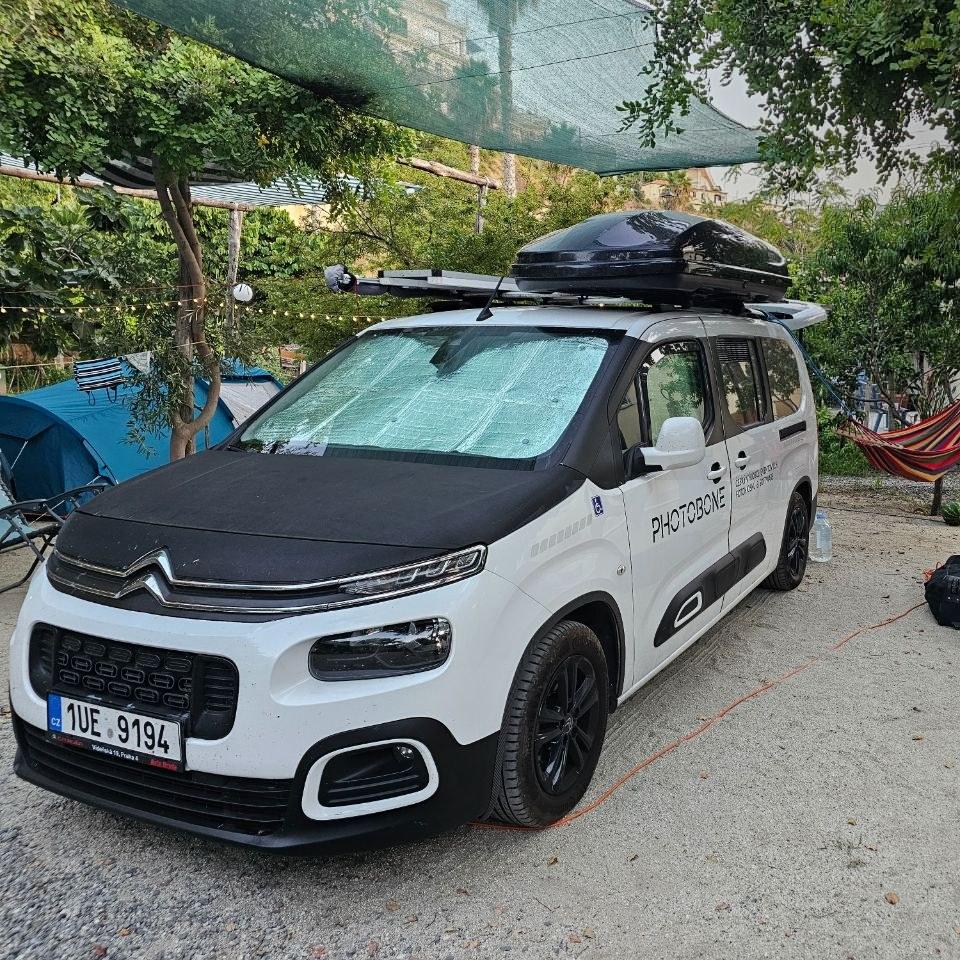 Auto se stahovacími clonami v předním okně na kempu